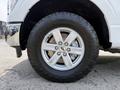 Close-up of a 2021 Ford F-150 wheel featuring a silver rim with five spokes and a rugged tire tread designed for off-road performance