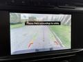 A 2021 Ford F-150 truck with a rearview camera display showing guidelines for parking and a message to check surroundings for safety