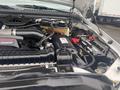 Engine compartment of a 2005 Ford F-350 SD featuring several components including the air intake system and battery with various wires and connectors visible