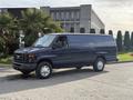 A blue 2011 Ford Econoline van parked on a driveway with a simple design and large side windows