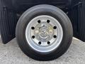 Close-up of a silver wheel from a 2013 RAM 5500 featuring shiny lug nuts and a black tire with visible tread patterns