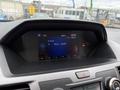 A dashboard of a 2014 Honda Odyssey displaying a digital radio interface with the FM frequency and time reading 12:37