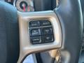 Close-up of a control panel on a 2015 RAM 1500 steering wheel featuring buttons for gear settings and cruise control functions
