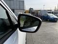 A side mirror of a white 2020 Ford Escape with a warning label about objects being closer than they appear