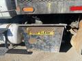A rusty metal box with a yellow label that reads "KEEP CLEAR" attached to the back of a 2014 International 7400 truck