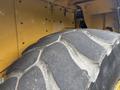 Close-up of a tire from a 2012 Caterpillar 980 showing deep treads and a rugged surface