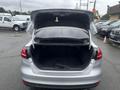 A 2018 Ford Focus with its rear hatch open revealing a spacious trunk area without any items inside