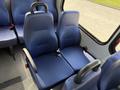 Two blue cloth seats designed for passenger transportation with adjustable headrests and seat belts in a vehicle interior