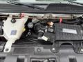 The engine compartment of a 2020 Chevrolet Express showing the engine assembly with various components including hoses and fluid reservoirs
