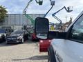 A 2013 RAM 5500 truck with a large side mirror parked among other vehicles including a Mercedes and construction equipment in the background