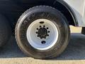 A large Goodyear tire mounted on a white rim with multiple lug nuts visible