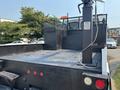 A 2006 Sterling Acterra truck with a flatbed design featuring a grid-patterned surface and a mounted crane system on the rear
