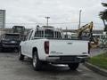 A white 2012 GMC Canyon pickup truck with a ladder rack in the bed parked in a lot