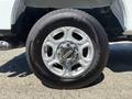 A close-up of a chrome wheel rim with a black tire featuring the Ford logo and distinctive spoke design