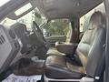 The interior of a 2009 Ford F-550 featuring two black leather seats and a central console