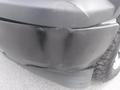 A close-up of the front bumper of a 2015 Chevrolet Silverado 1500 showing visible scratches and dents on the surface