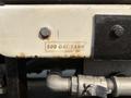 A label on a 2009 Ford F-550 indicating a 500 gallon tank with visible surface rust and metal fittings attached to it