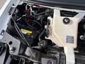 A close-up view of the engine compartment of a 2018 Chevrolet Express showing various components including the battery coolant reservoir and wiring