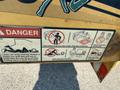 A warning label on a Vermeer Corporation BC1200XL wood chipper featuring safety instructions and hazard symbols related to limb entanglement and proper operation procedures