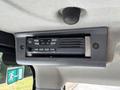 A Kenwood radio mounted on the interior roof of a 2010 Bobcat E80 operator's cabin with buttons and a display for controlling audio functions