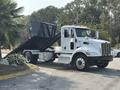 A white 2020 Peterbilt 330 dump truck with a raised bed for unloading materials