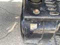 Close-up of a black machinery part with a label indicating diesel fuel use and components related to the carburetor on a 1996 GMC Top Kick