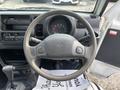 Interior view of a 2010 Daihatsu Hijet showing the steering wheel dashboard and gear shift