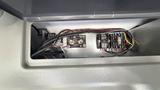 A 2021 Ford Transit with exposed wiring and electrical components including fuses and connectors in a panel compartment