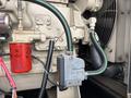 A 2005 Katolight SED60FPJ4 generator showing various components including a red oil filter and a control module with wiring and hoses attached