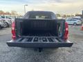 A 2011 Chevrolet Avalanche with its tailgate down and an open, empty bed displaying a black rubber liner