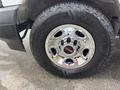 Close-up view of a chrome wheel with the GMC logo and Goodyear Wrangler tire mounted on a 2022 GMC Savana
