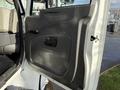 A close-up of the driver's side door panel of a 2010 International 4300 featuring a gray plastic design with a handle and a small window control