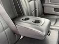 The image shows the center console of a 2018 RAM 1500 with a fold-down armrest featuring two cup holders