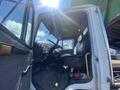 Interior view of a 1997 Freightliner FL70 truck showcasing the driver's seat dashboard and steering wheel with visible controls and equipment