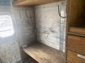Interior of a 2007 Morgan Olson Workhorse W42 featuring wooden shelves hooks and a metal panel with wear marks