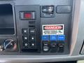 Control panel of a 2020 Peterbilt 330 featuring various switches buttons and warning indicators including a danger sign and lights controls