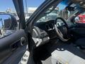 Interior view of a 2010 Toyota Tacoma showing the dashboard steering wheel and control panel with cloth seats and window controls