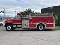 A red 2002 GMC C7500 fire truck with a large water tank and various firefighting equipment on the sides and back