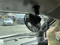 A small black fan mounted on the dashboard of a 2020 Chevrolet Express