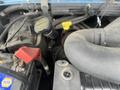 A close-up view of the engine compartment of a 2006 Ford Econoline showing various components including hoses and battery terminals