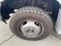 A close-up of a tire mounted on a 2003 Ford F-450 SD showing detailed tread pattern and silver wheel rim with lug nuts