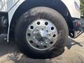 Close-up of a 2014 Freightliner M2 106 wheel with a shiny chrome rim and large black tire showcasing multiple bolt holes