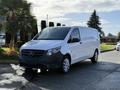 A 2020 Mercedes-Benz Metris van with a white exterior and black accents parked on a driveway surrounded by green plants