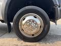 A close-up of a wheel and tire from a 2009 Ford F-450 Super Duty featuring a shiny chrome hubcap and black tire sidewall