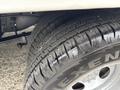 Close-up of the tires on a 2014 Ford E-350 showing detailed tread patterns and tire brand lettering
