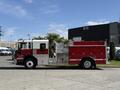 A 1994 Volvo FE 42 fire truck featuring a red and white color scheme with a pump and hose compartment on its side