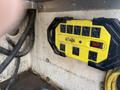 A yellow power strip with multiple outlets and a switch mounted on a surface with visible wiring nearby