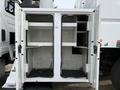 Open storage compartments of a 2011 International 4300 truck with shelves and a blank interior