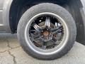 A close-up view of a black alloy wheel with a five-spoke design mounted on a 2017 RAM 1500 tire featuring visible treads and branding on the sidewall