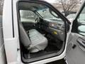 The interior of a 2006 Ford F-450 showing the front seat and dashboard with a gray seat and controls visible